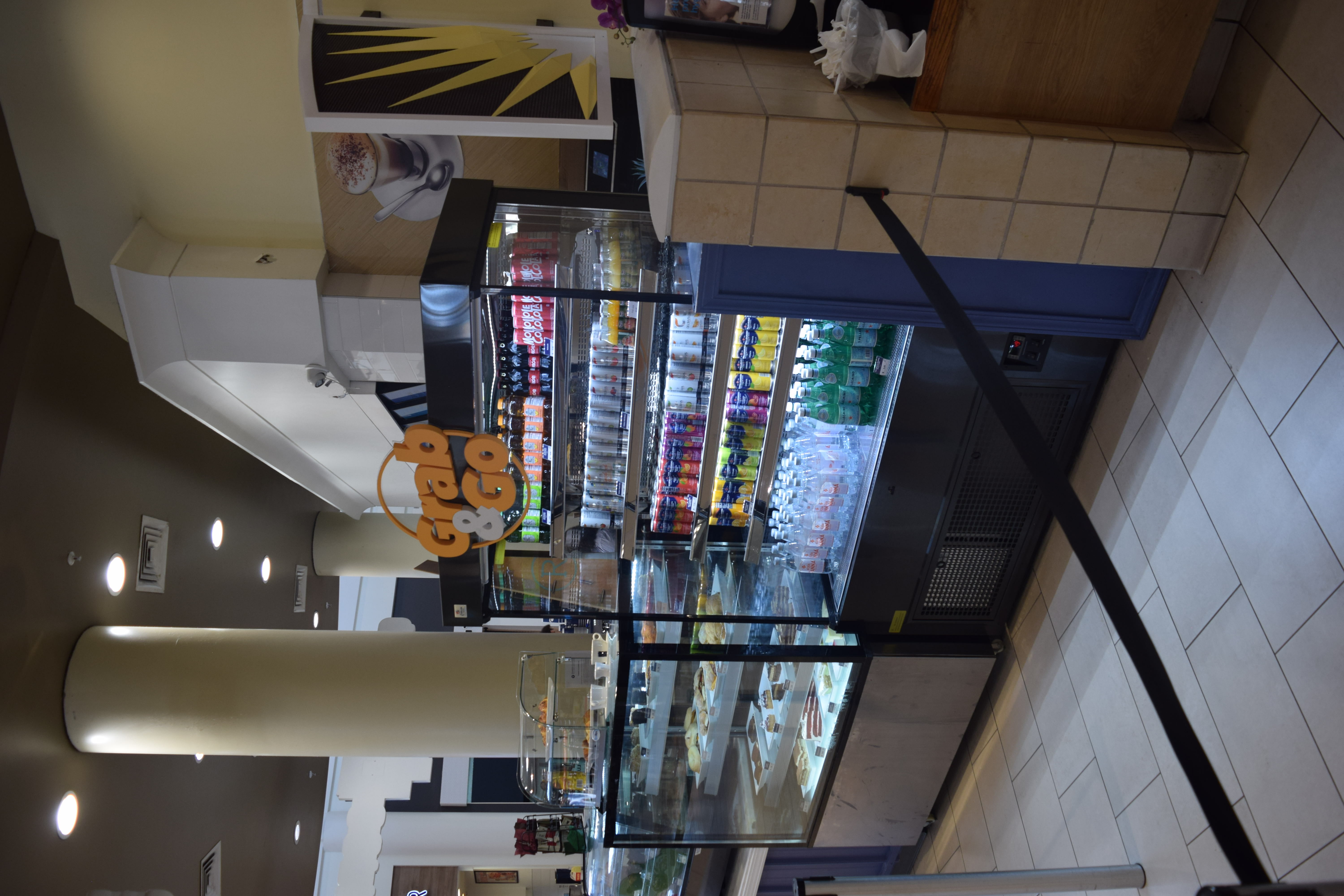 Grab & Go display stocked with non-approved bottled beverages — Mole Cola, Pellegrino, Acqua Panna and other unauthorized brands