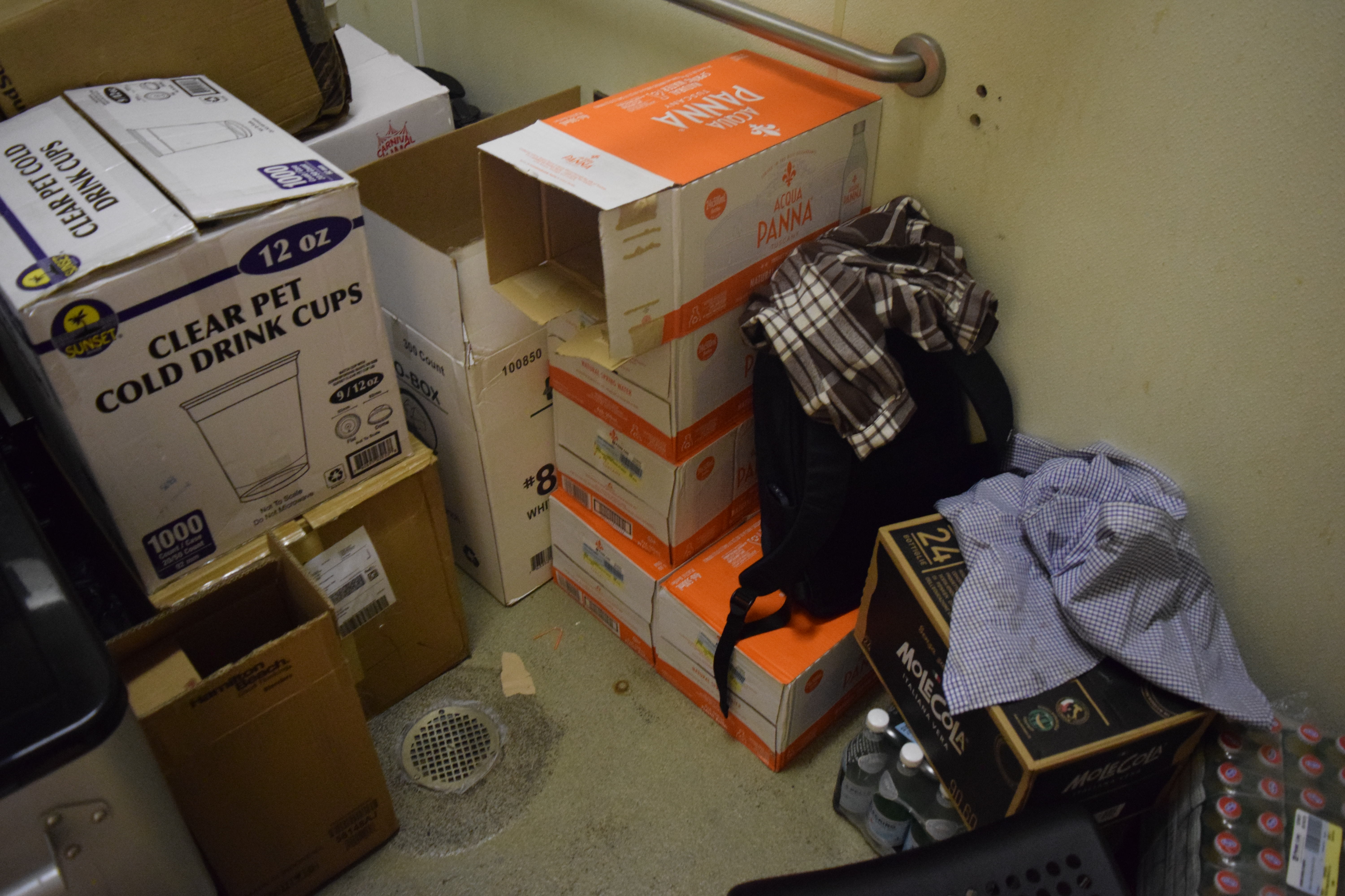 Restroom floor packed with stored cases of unauthorized bottled water and soda