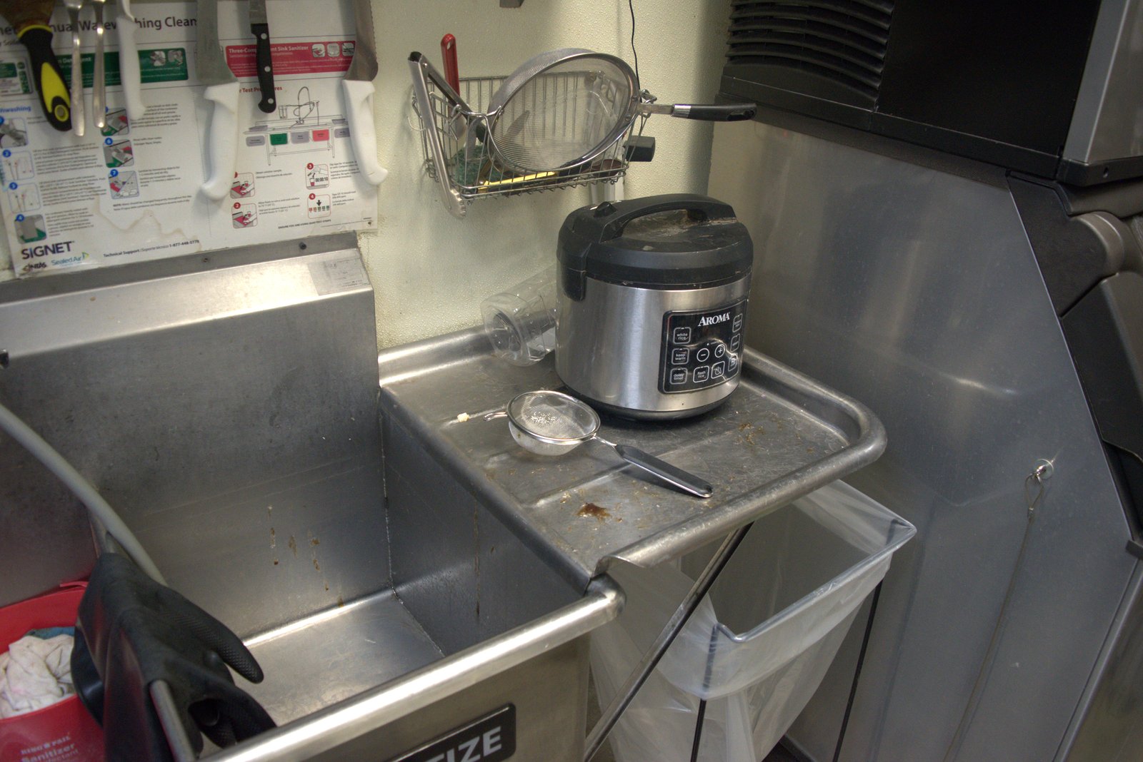Aroma rice cooker (unauthorized substitute for the approved boba cooker) sitting on a dirty, food-debris-covered sink drainboard