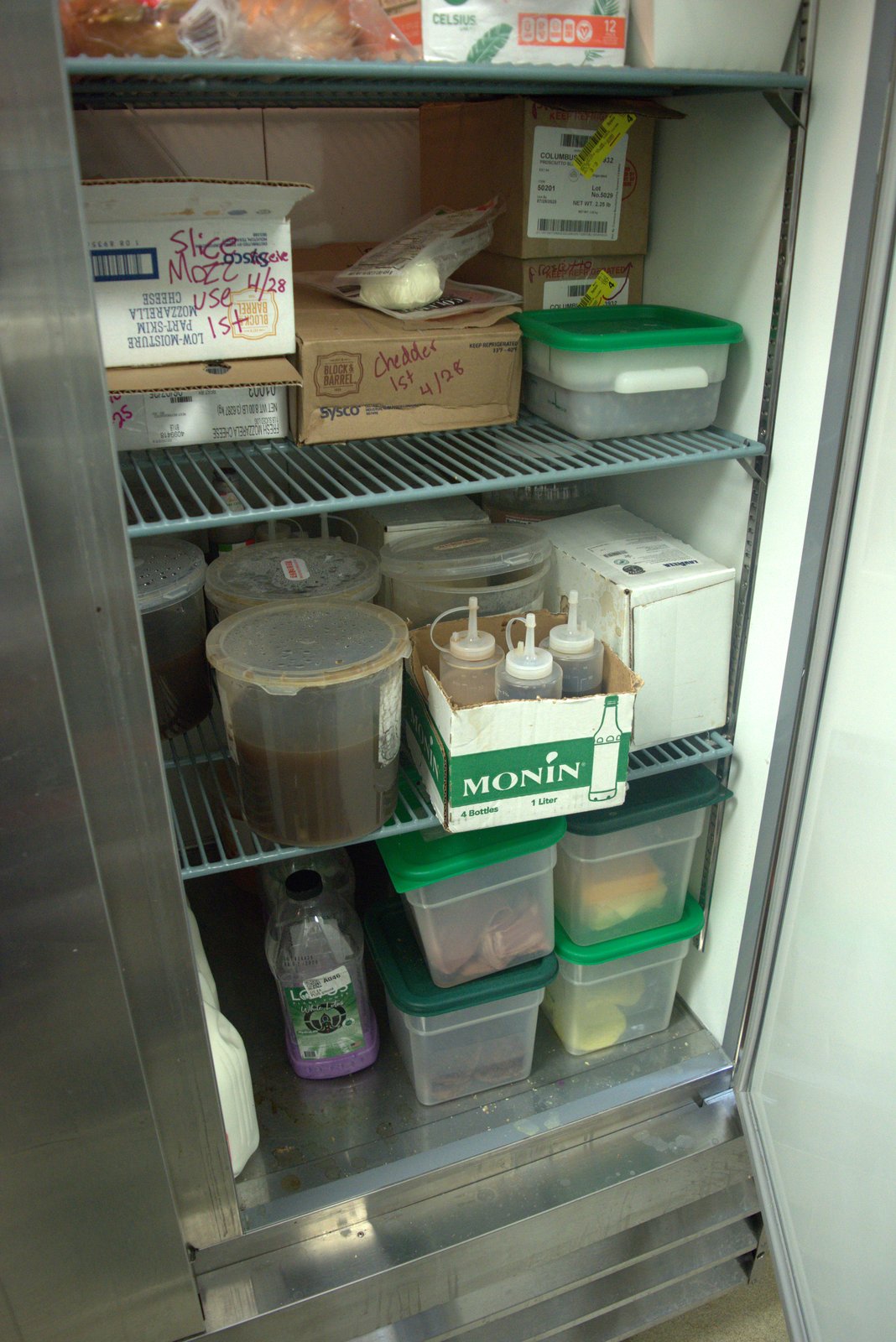 Cheese boxes marked 'Use 1st 4/28' photographed during the May inspection — well past the use-by note