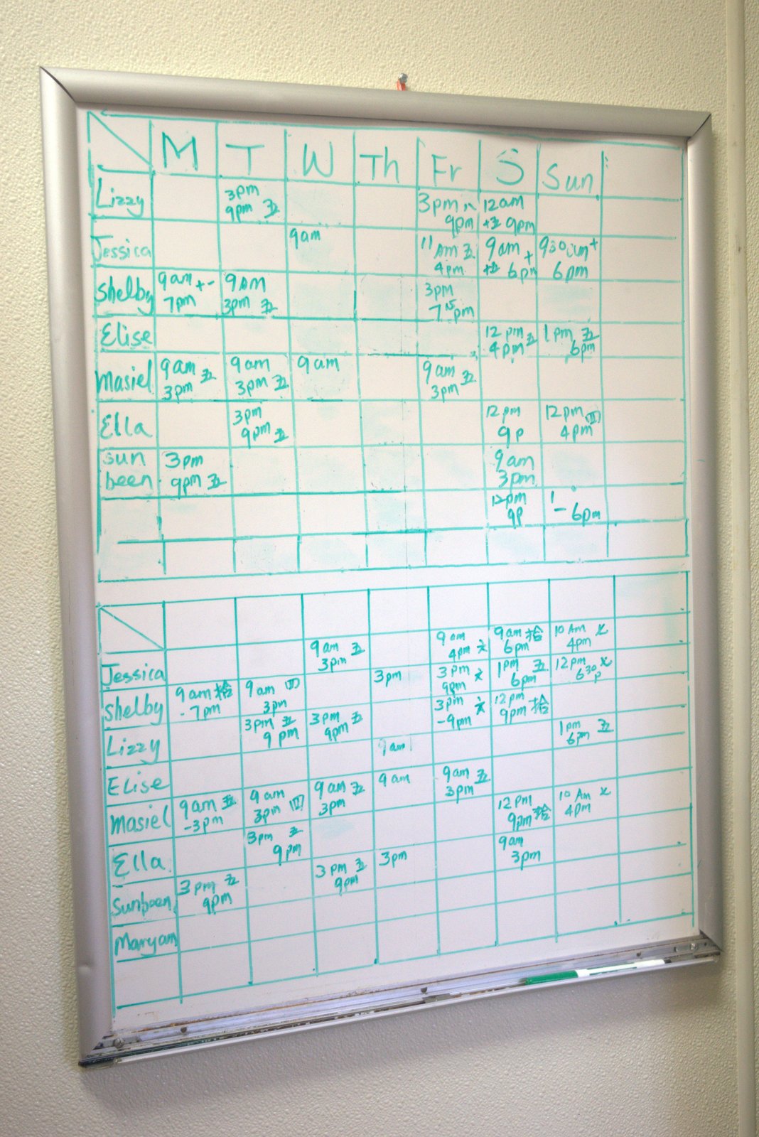 Hand-drawn whiteboard staff schedule with Chinese-character annotations — required corporate scheduling system not in use