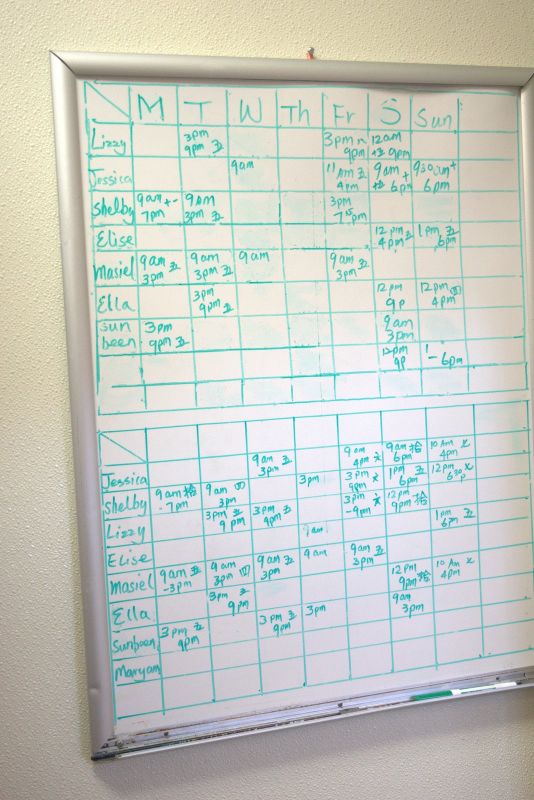 Same whiteboard schedule, closer view — informal handwritten shifts replacing the franchisor-mandated digital scheduling platform