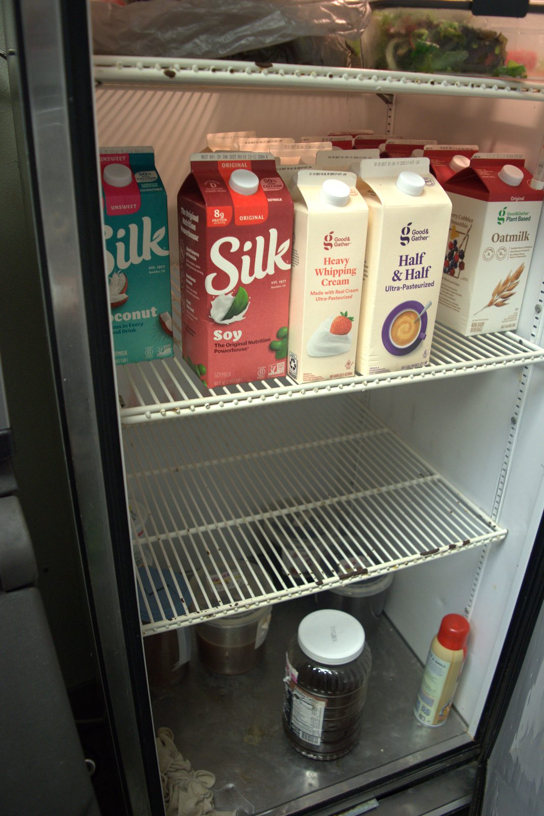 Same dairy shelf, closer view — Target-house-brand 'Good & Gather' cartons confirm retail-grade product purchased from a grocery store rather than the franchisor's approved distributor