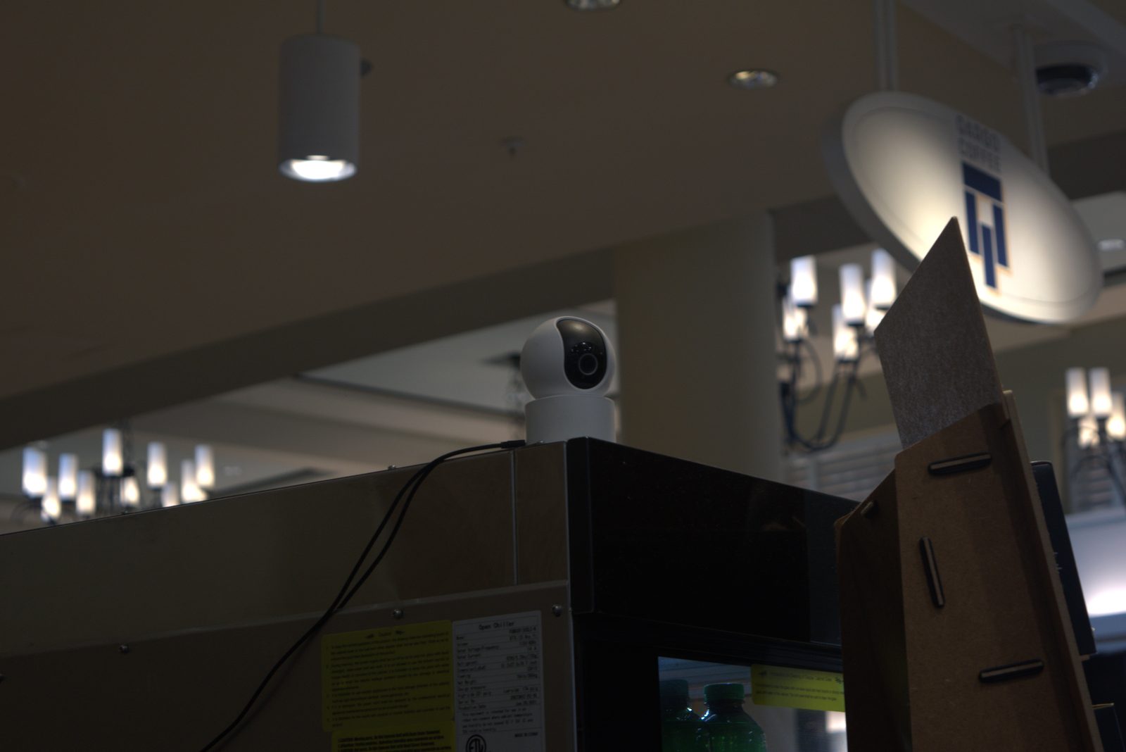 Open trash bin sitting against a structural column directly beside the bakery display case